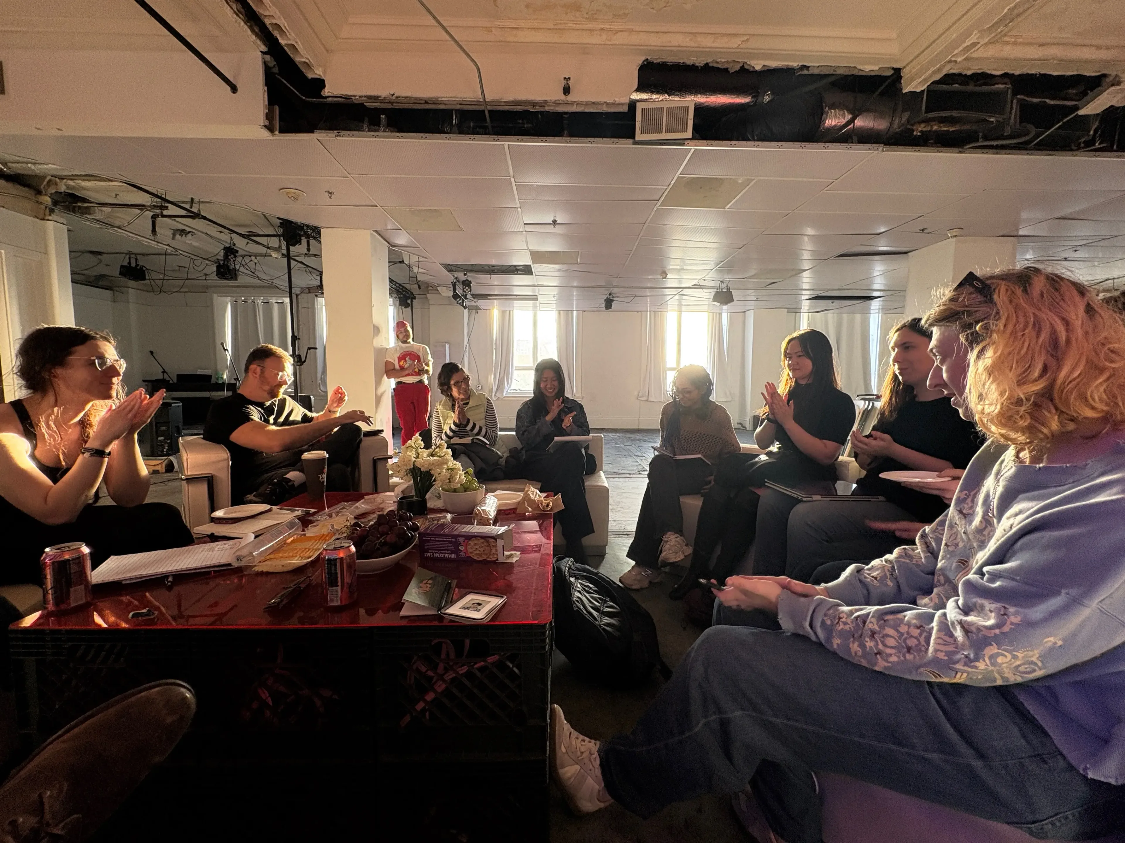 A daylight circle of people sitting and applauding at a Dreamshare roundtable